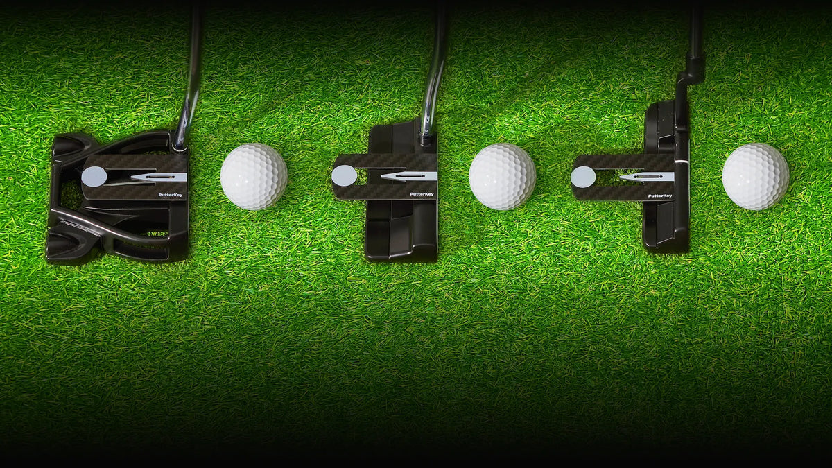 Putter Key putting stroke trainer attached to a putter on the green next to a golf ball