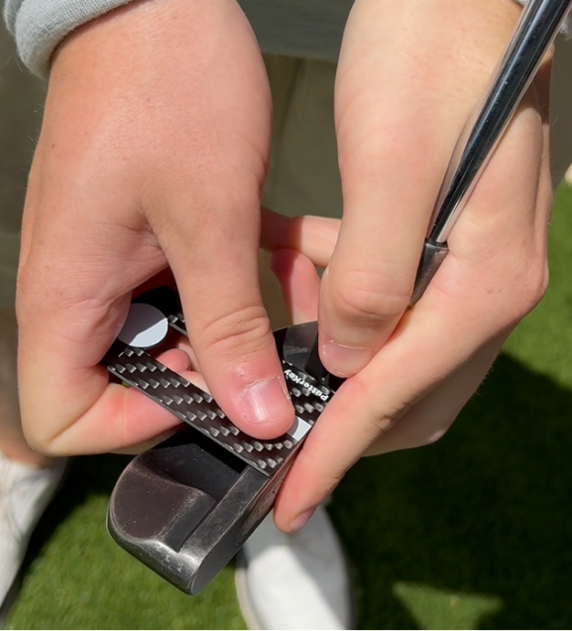 Golfer showing how to place Putter Key on blade putter
